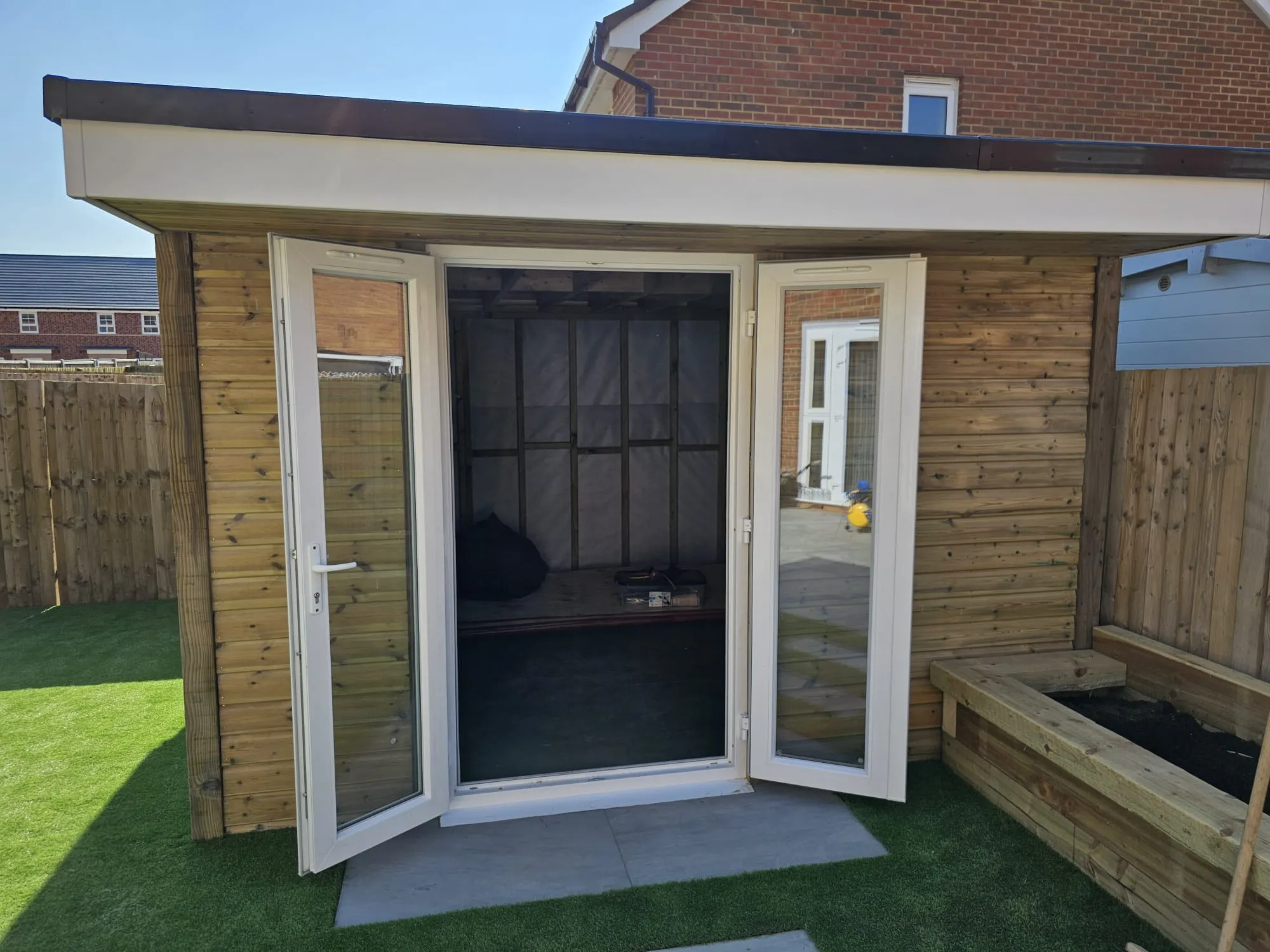 A small wooden shed with a sliding glass door.