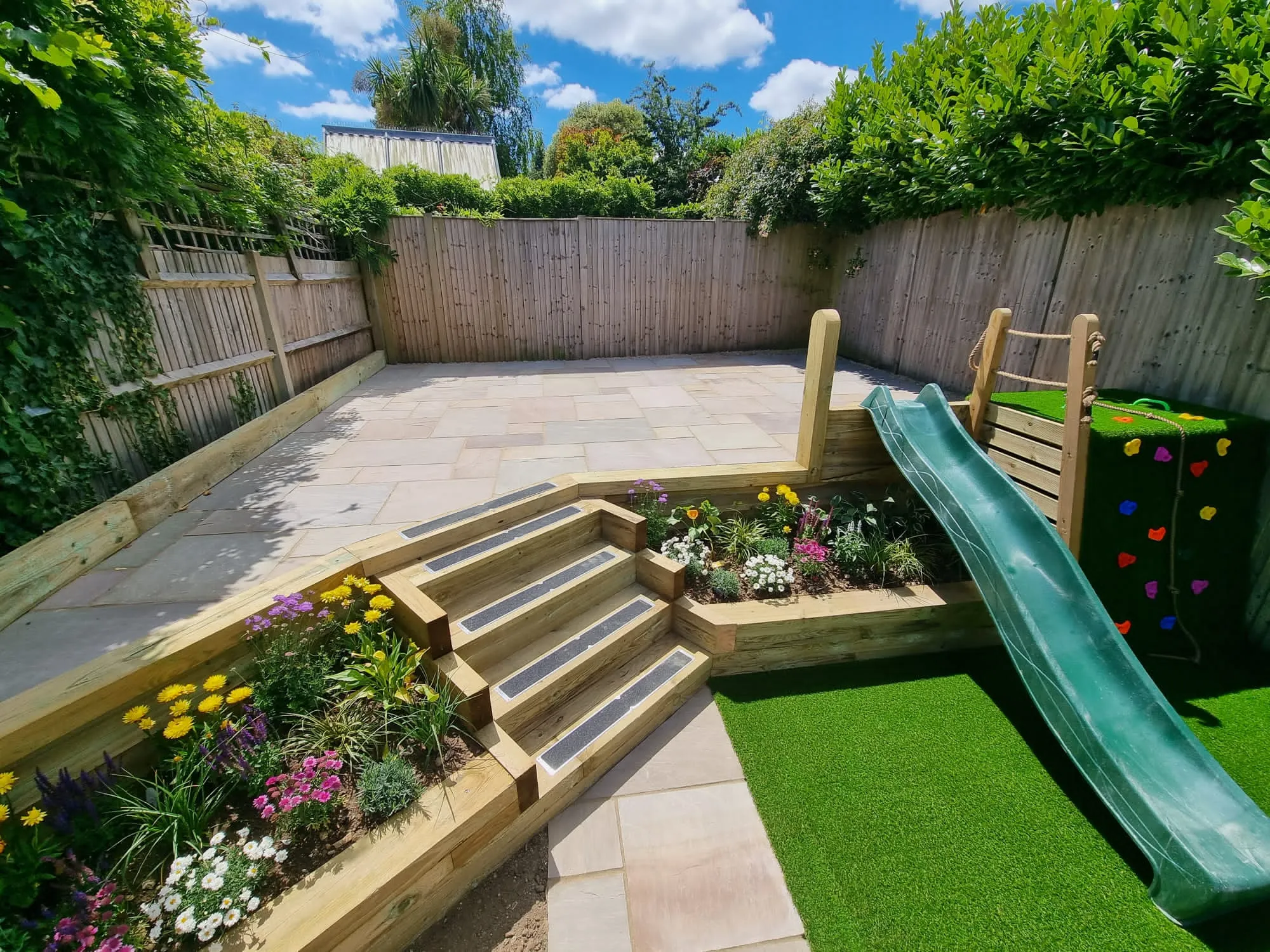 a backyard with a slide and flower garden