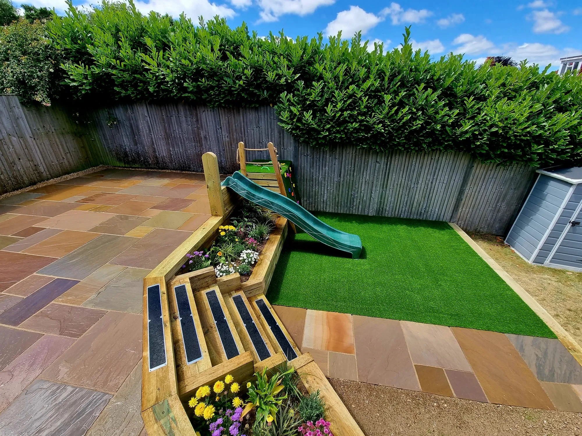 a backyard with a slide and flower boxes