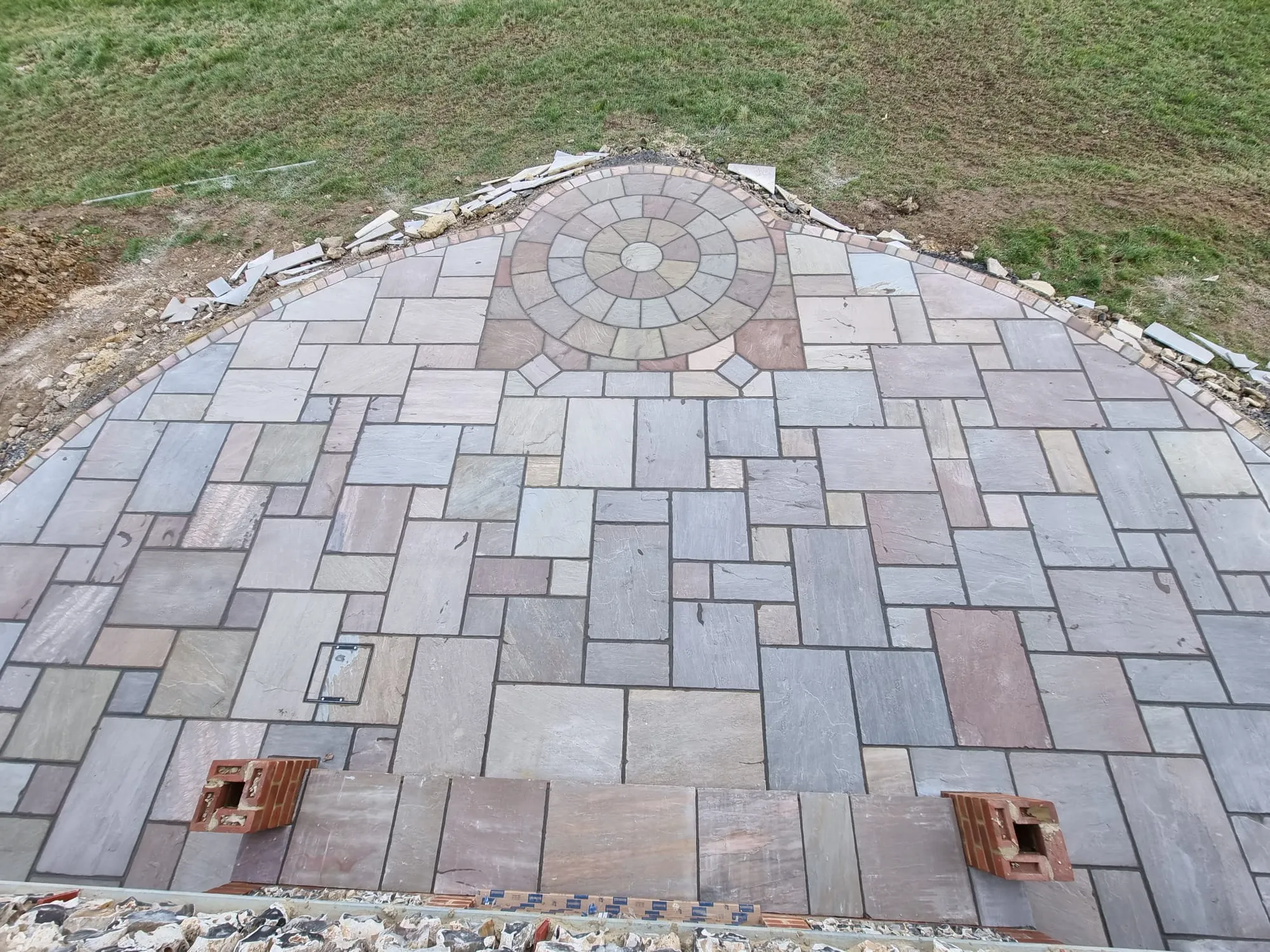 an aerial view of a stone walkway in a field
