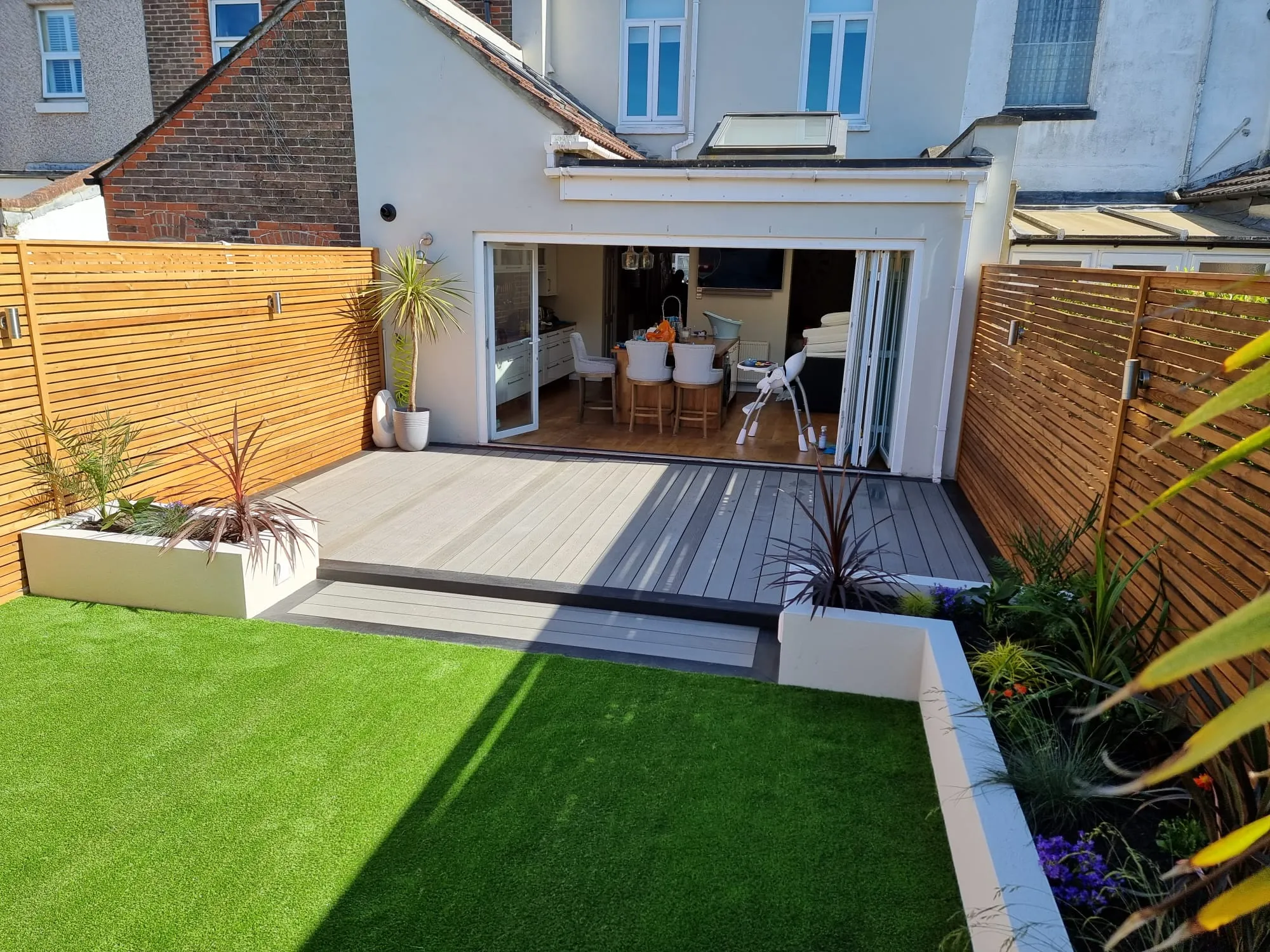 a backyard with a wooden deck and grass