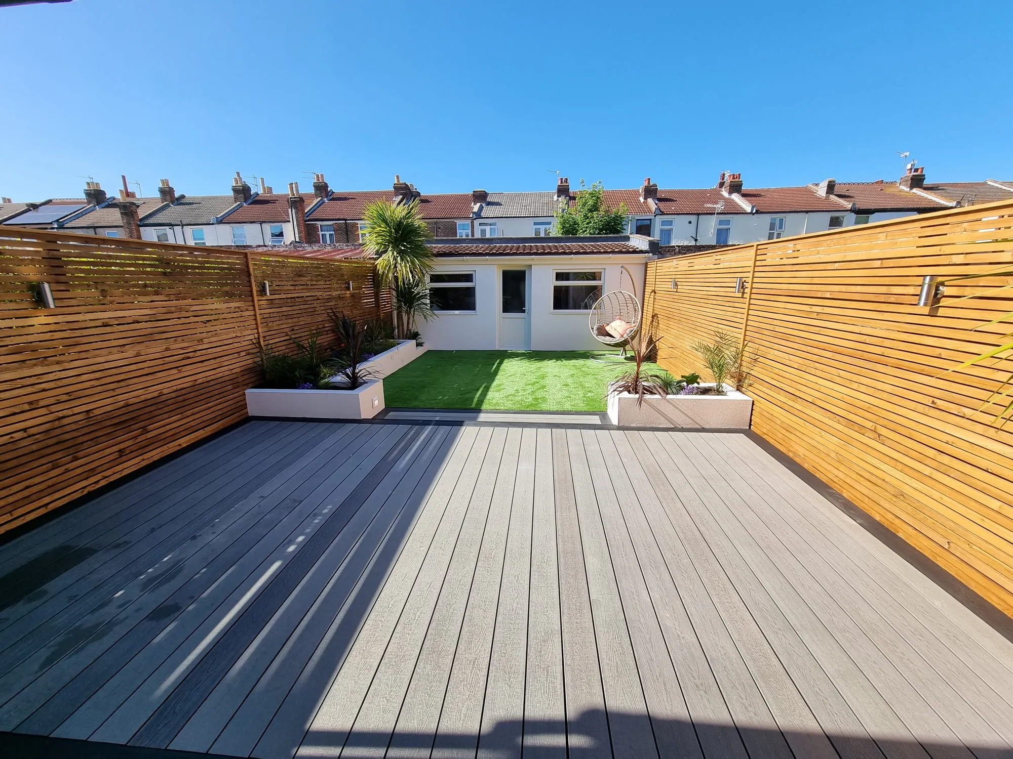 a backyard with a wooden fence and a wooden deck