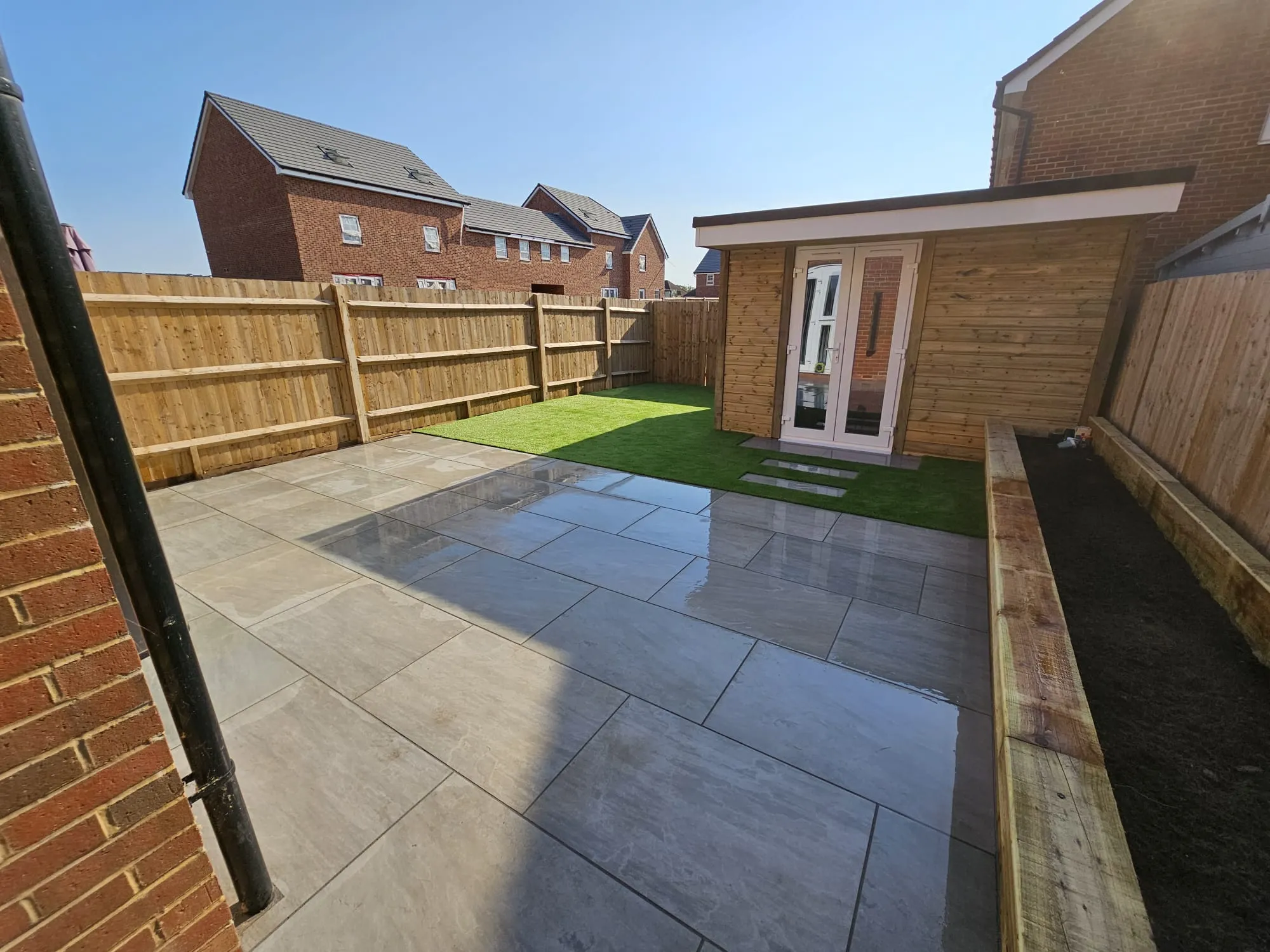a back yard with a brick fence and grass
