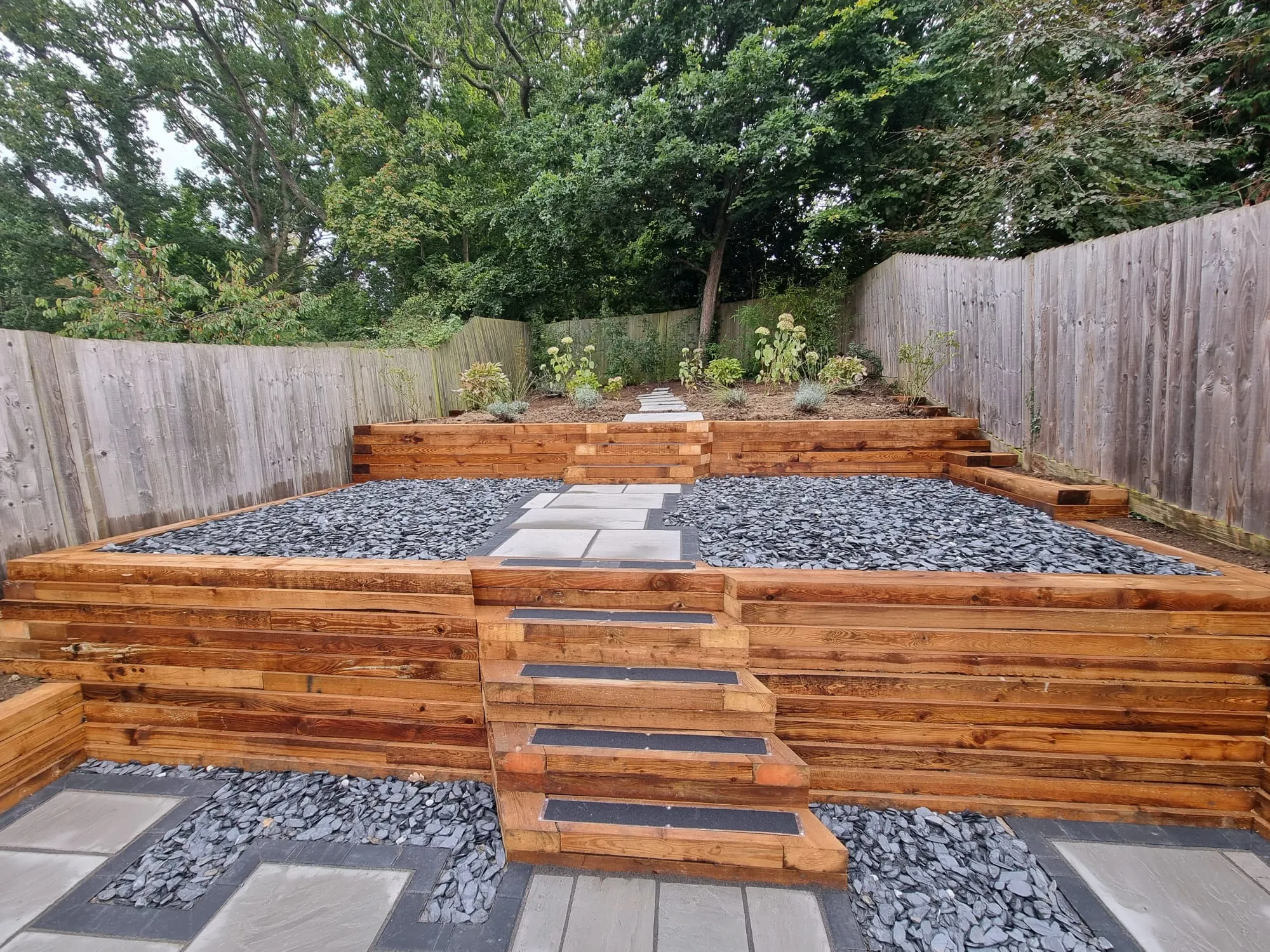 a backyard with a wooden fence and a stone walkway