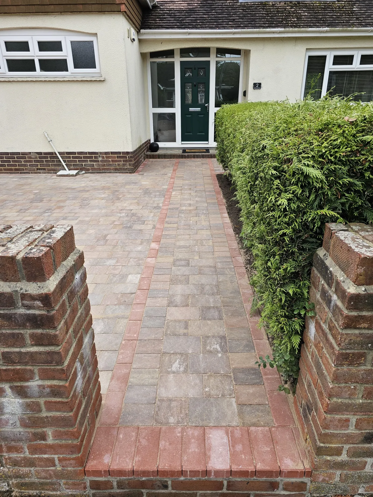 a brick walkway leading to a front door of a house