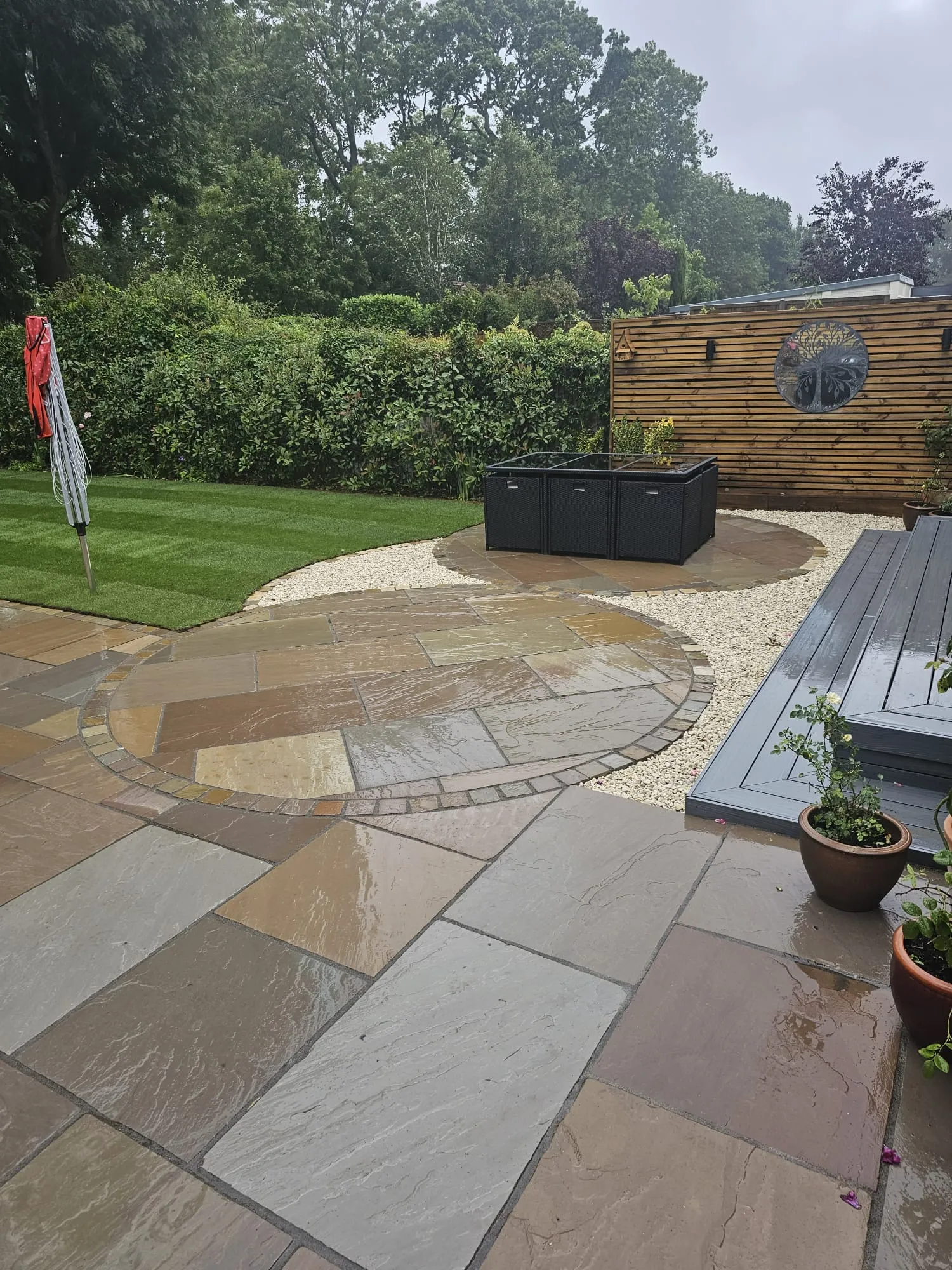 a patio area with a wooden bench and potted plants