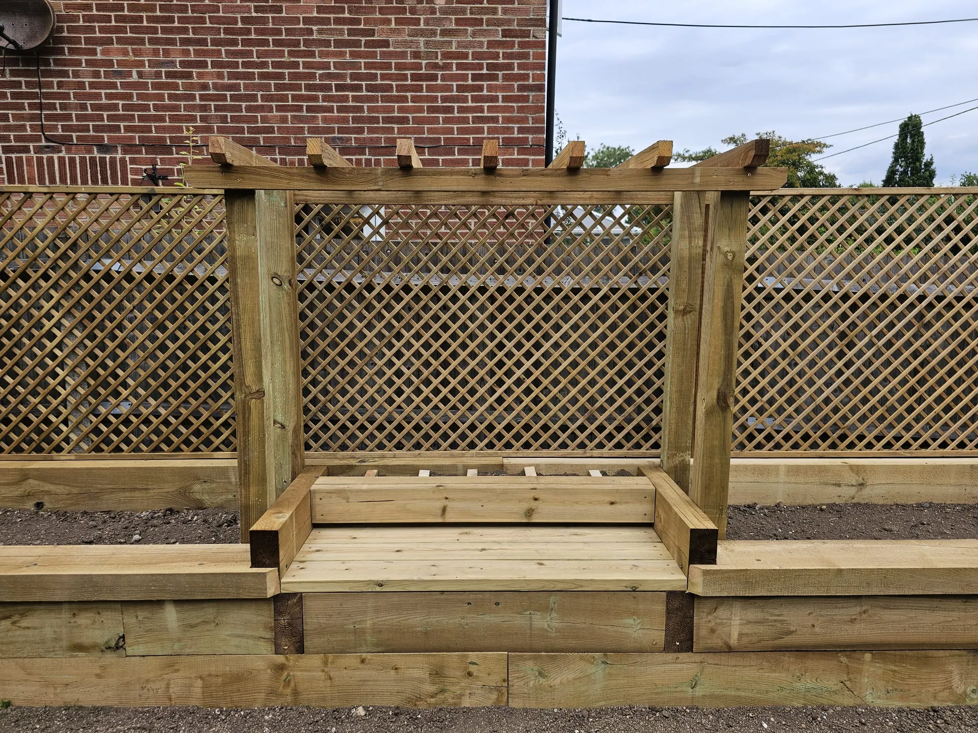 a wooden bench sitting next to a fence