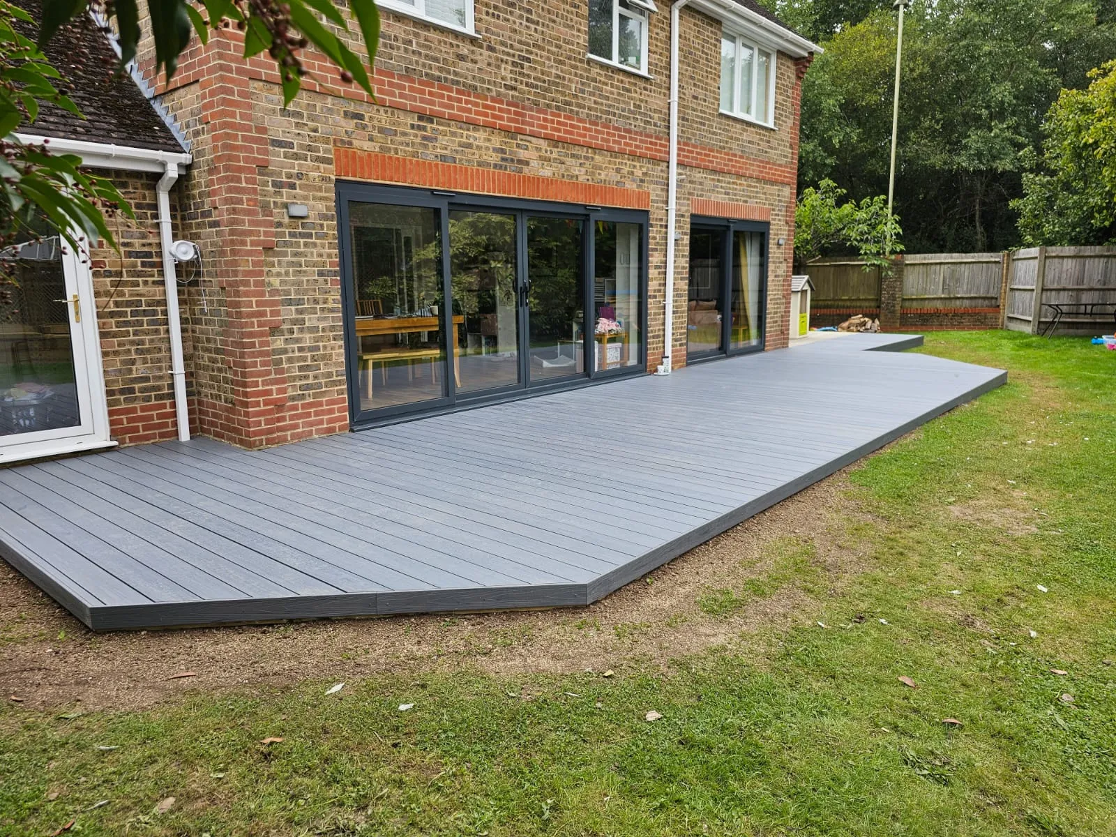 a large wooden deck in front of a brick building
